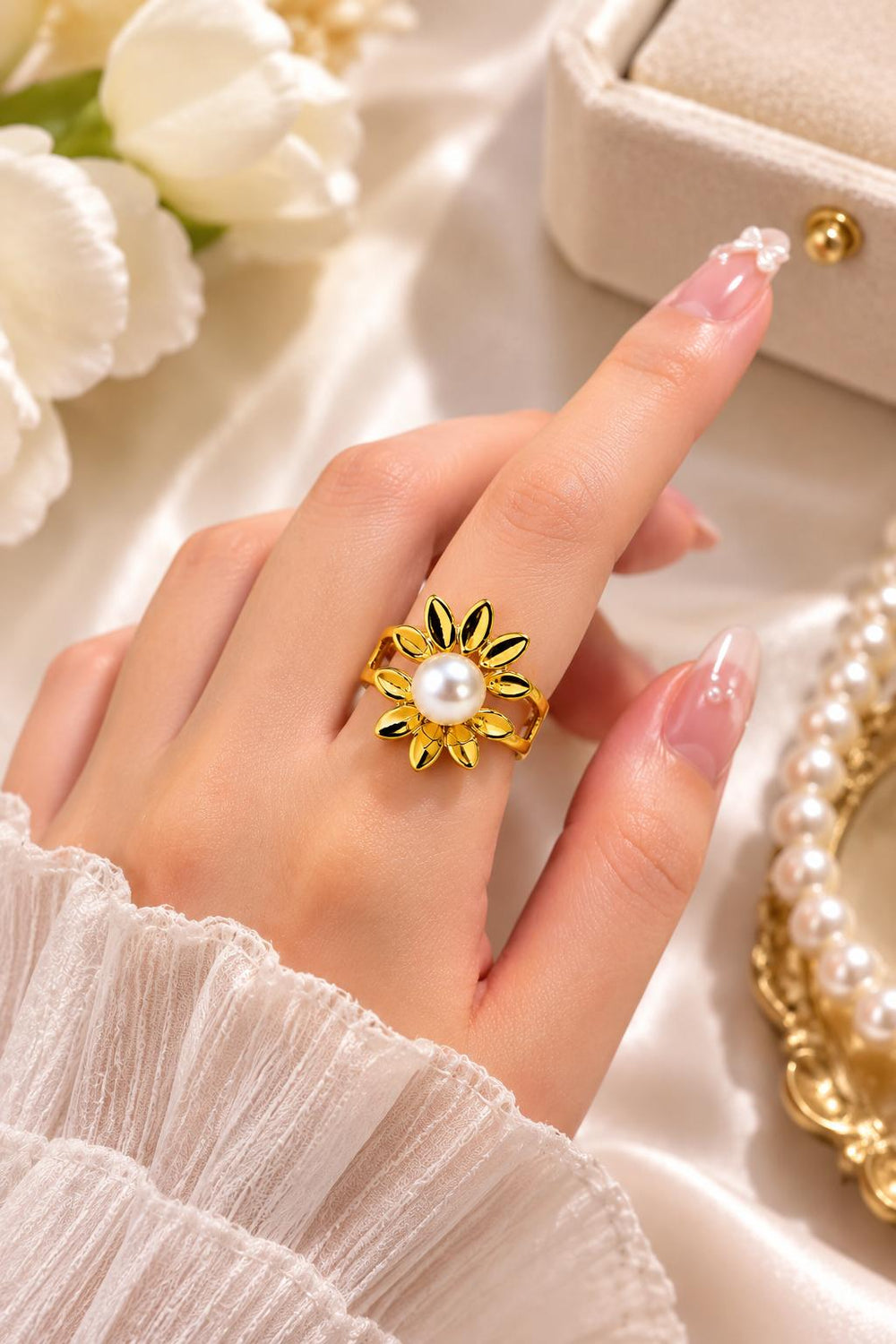 Gold flower pearl ring on finger