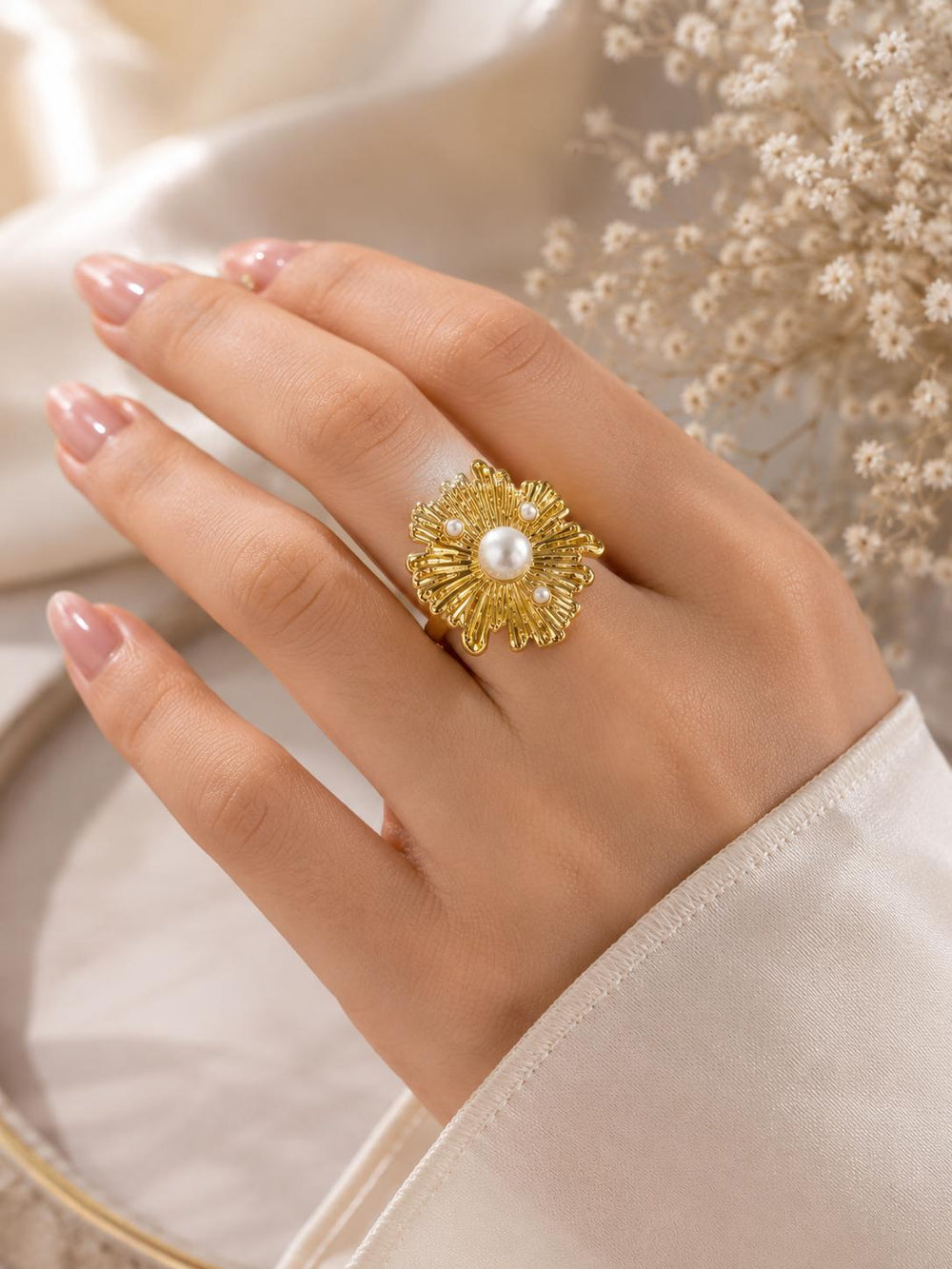 Gold flower pearl ring on hand angle