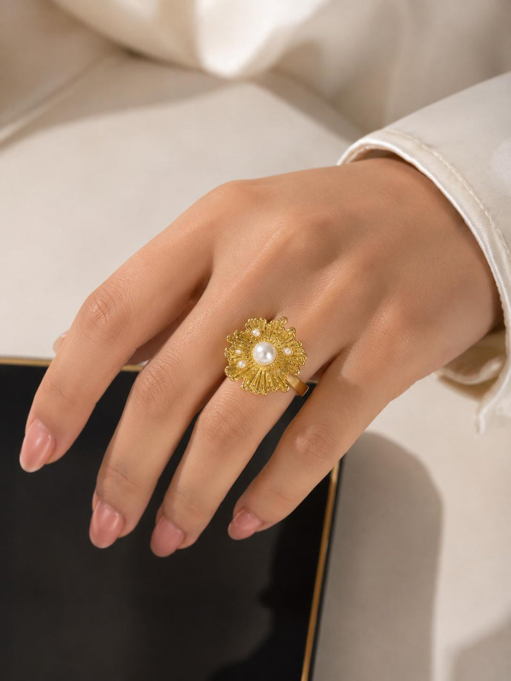 Gold flower pearl ring on hand close